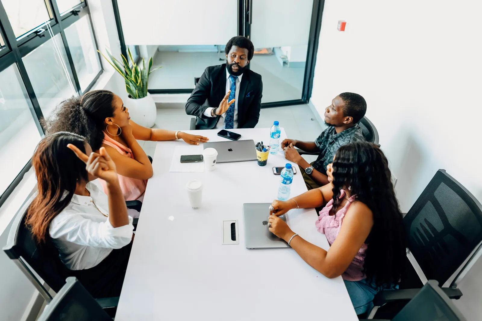 A small team gathered around a table in an open, animated working discussion
