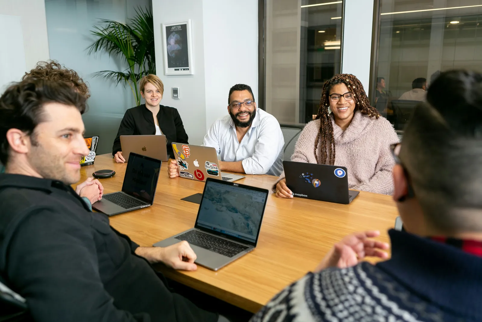 A team collaborating and smiling around a conference table